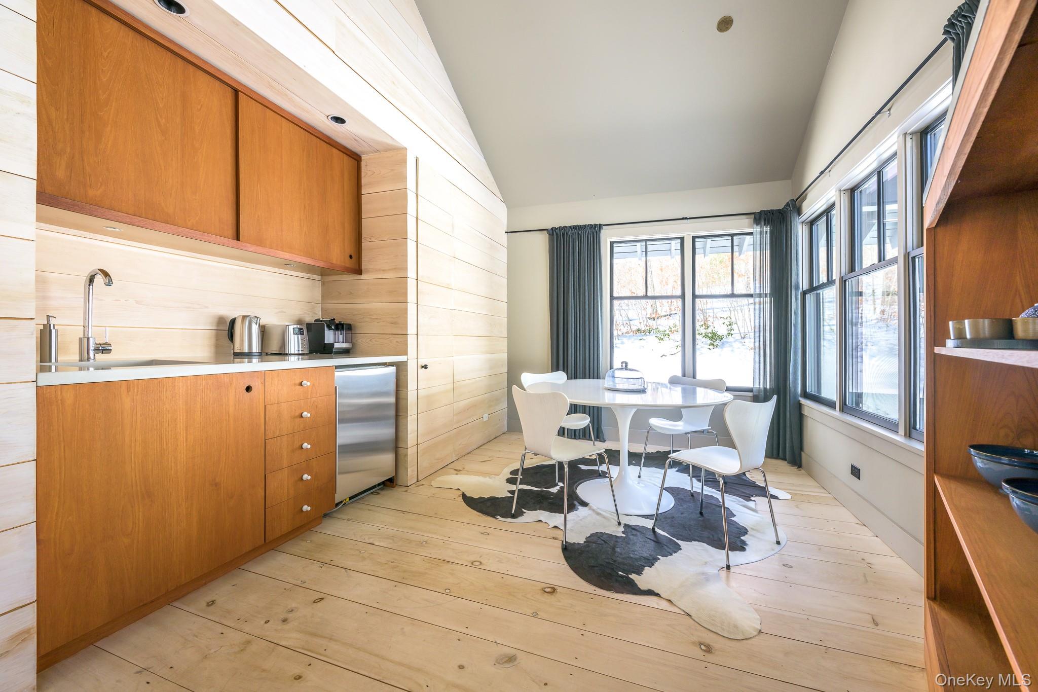 890 Bald Mountain Road Austerlitz, NY 12017 - Photo 26 of 28 Kitchen with brown cabinets, vaulted ceiling, stainless steel fridge, light wood-type flooring, and modern cabinets