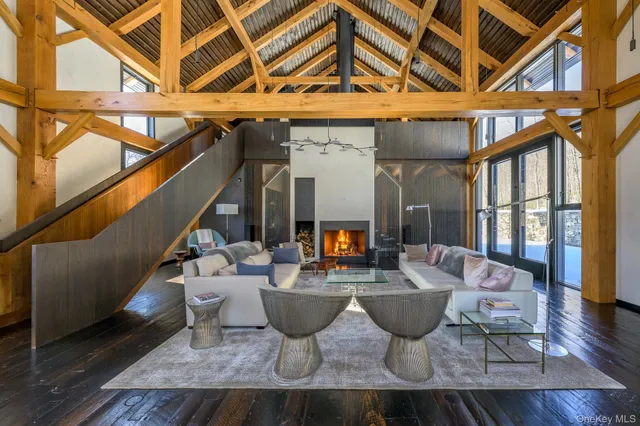 a living room with furniture a flat screen tv and floor to ceiling windows