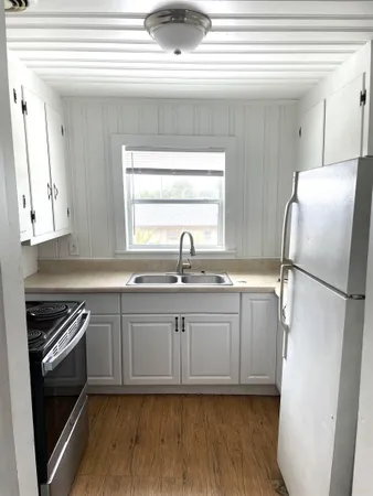 a kitchen with stainless steel appliances a refrigerator sink and cabinets