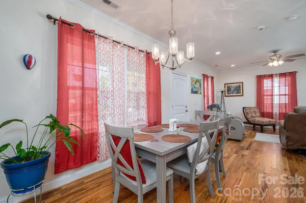 a view of a dining room with furniture a chandelier and wooden floor