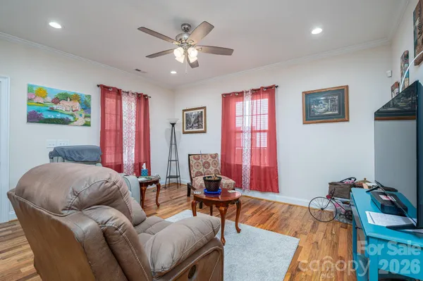 a open kitchen with stainless steel appliances granite countertop a sink dishwasher and a flat tv screen next to a dining table with wooden floor