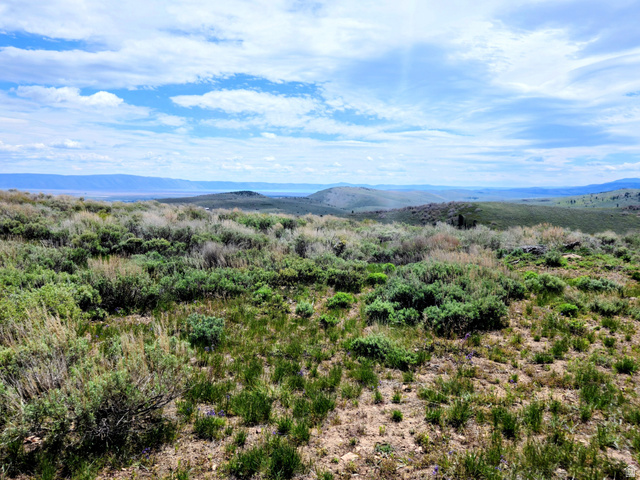 4005 Mill Canyon Road Montpelier, ID 83254 - Photo 5 of 6 Expansive natural landscape featuring rolling hills and distant mountains under a blue sky with scattered clouds