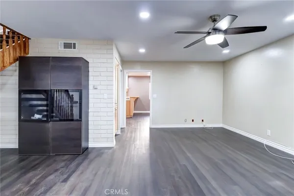 a view of a kitchen with a dishwasher a kitchen wooden floor and a ceiling fan