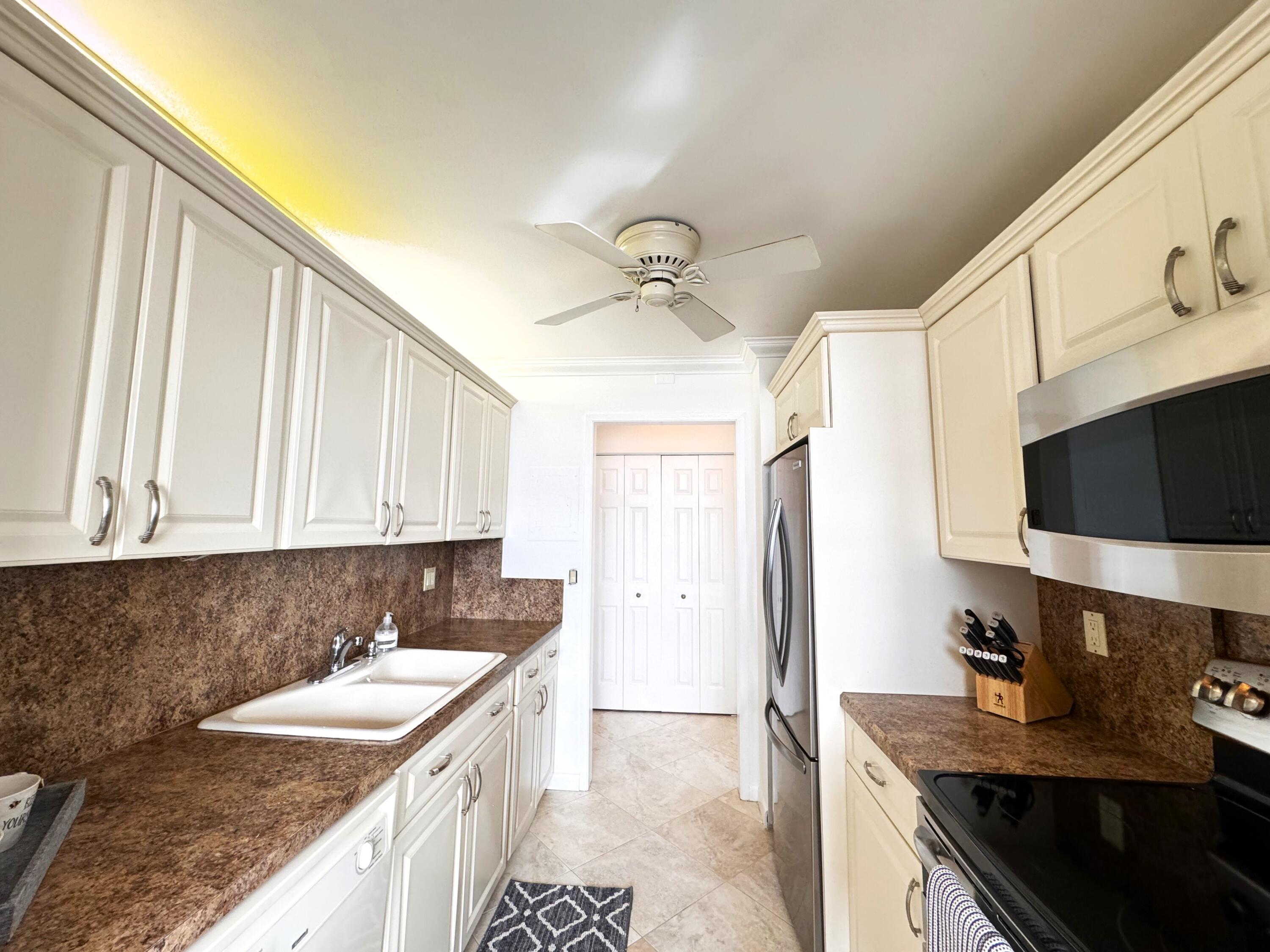 2121 North Ocean Boulevard, Unit 609W Boca Raton, FL 33431 - Photo 8 of 27 a kitchen with a sink stove and refrigerator