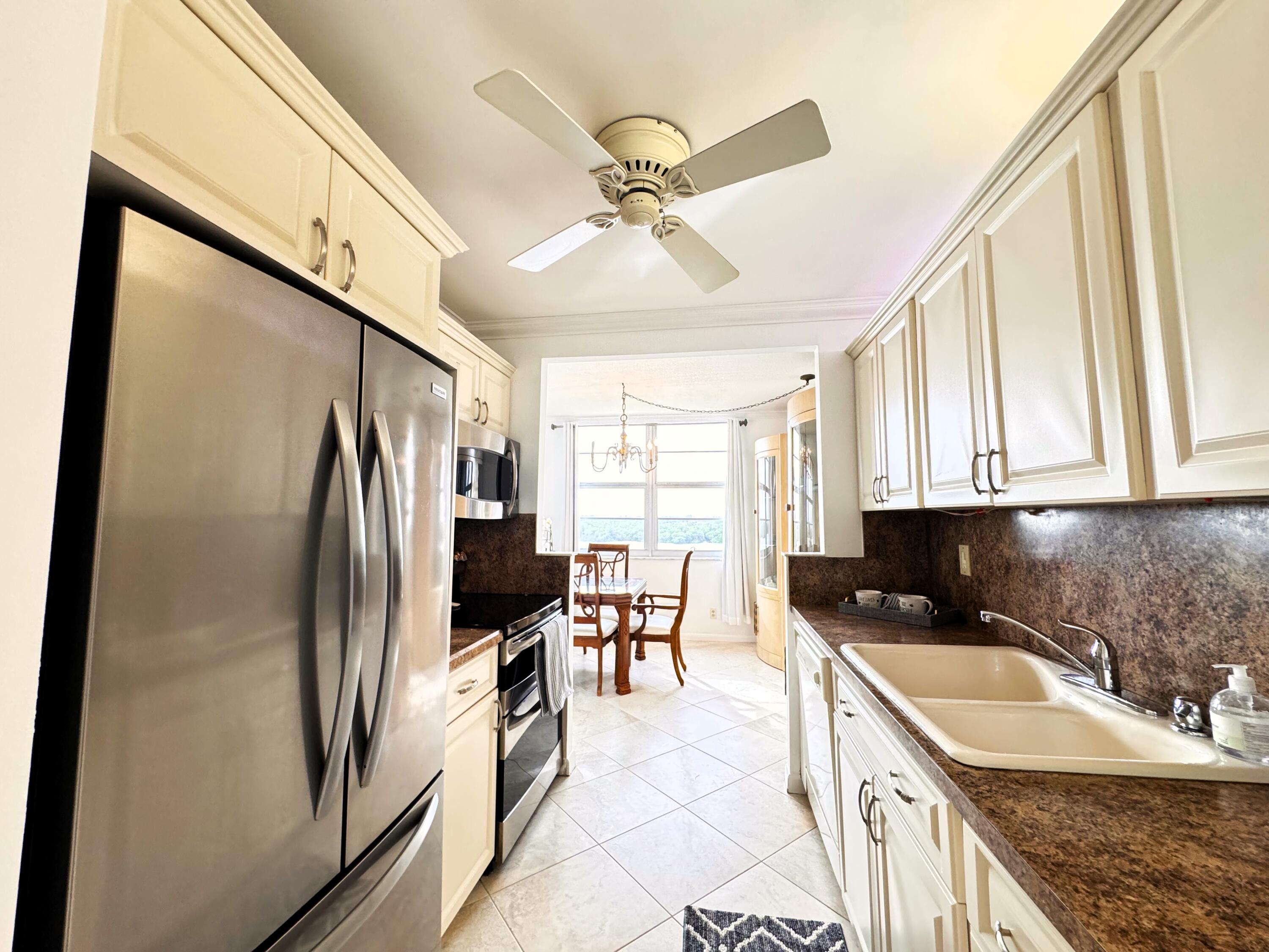 2121 North Ocean Boulevard, Unit 609W Boca Raton, FL 33431 - Photo 9 of 27 a kitchen with stainless steel appliances granite countertop a refrigerator a sink a stove and island
