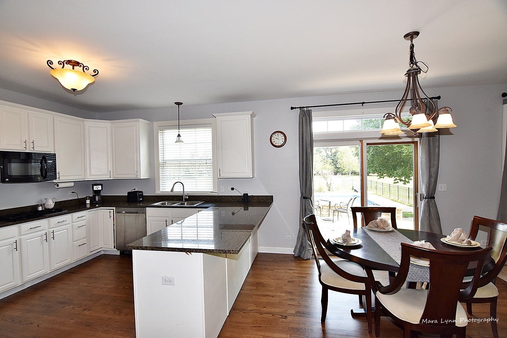37W200 Red Gate Road St. Charles, IL 60175 - Photo 8 of 47 a kitchen with granite countertop a stove a sink a dining table and chairs with wooden floor