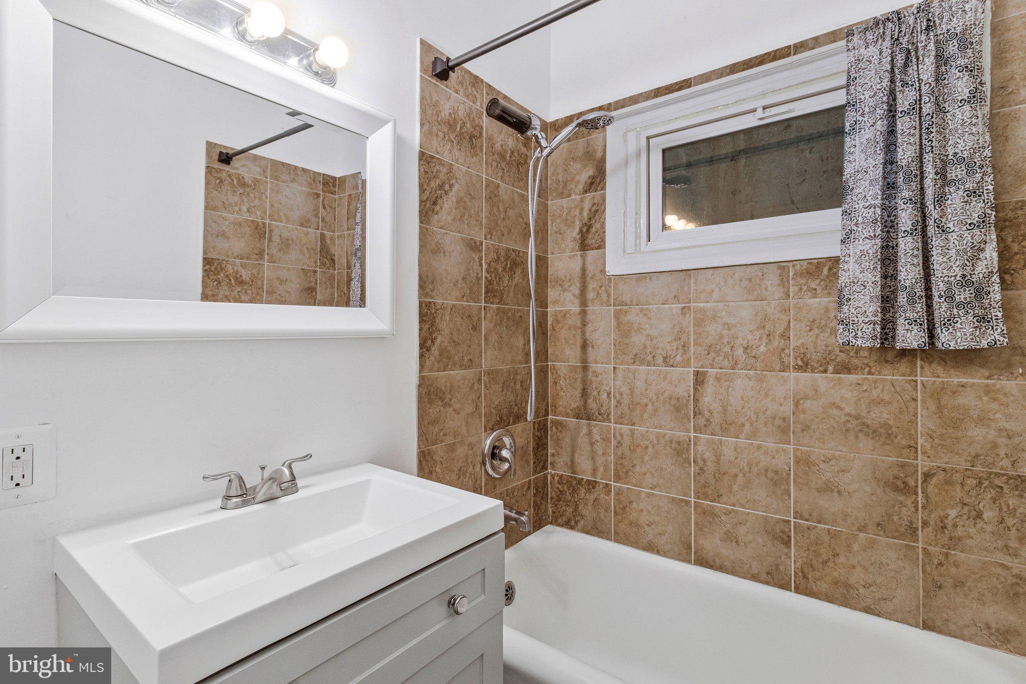 1111 Queen Street Northeast, Unit 3 Washington, DC 20002 - Photo 4 of 8 a bathroom with a sink mirror toilet and bathtub