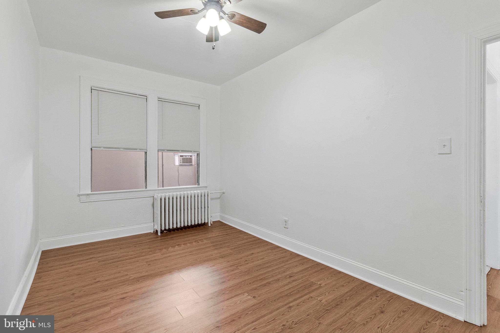1111 Queen Street Northeast, Unit 3 Washington, DC 20002 - Photo 5 of 8 an empty room with wooden floor and chandelier