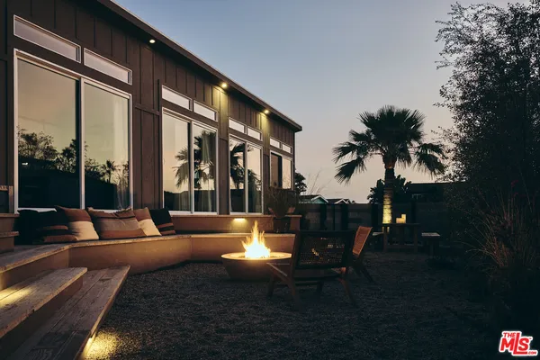 a living room with patio furniture and potted plants