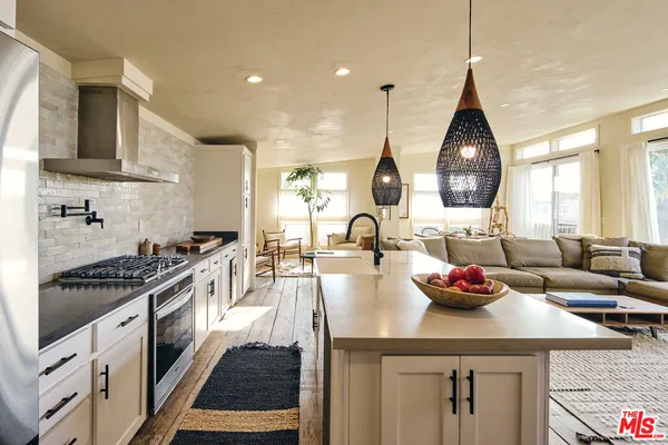 a kitchen with a sink a stove and chairs