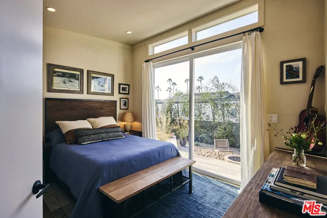 a bedroom with a bed and a couch next to a window