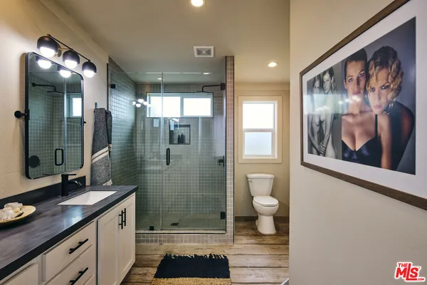 a bathroom with a double vanity sink toilet and shower