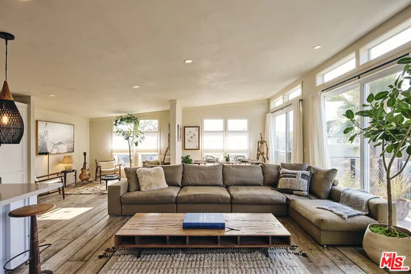 a living room with furniture wooden floor and a large window