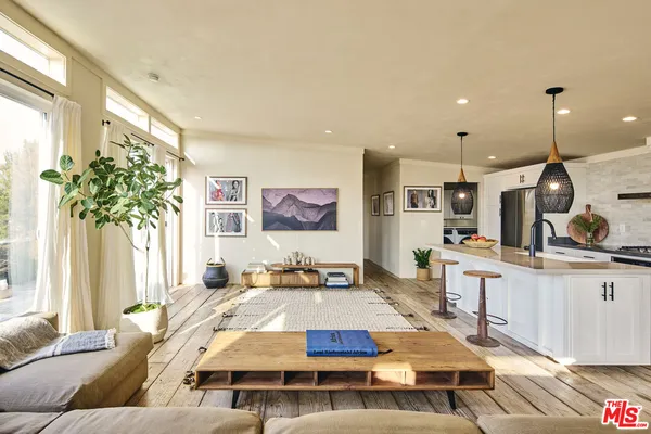 a living room with kitchen island furniture and a chandelier