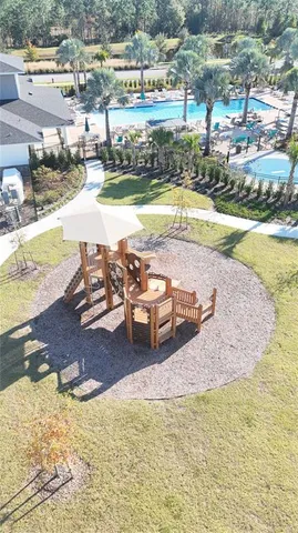 an aerial view of a house with swimming pool and a yard