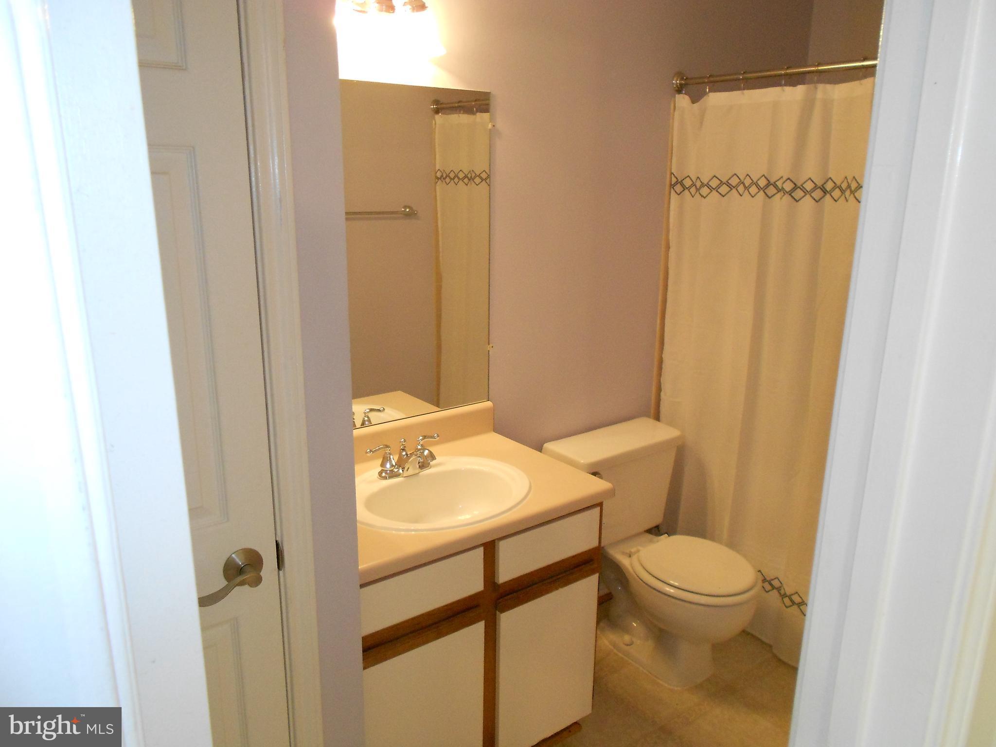 20950 Timber Ridge Terrace, Unit 203 Ashburn, VA 20147 - Photo 11 of 30 a bathroom with a toilet a sink and shower