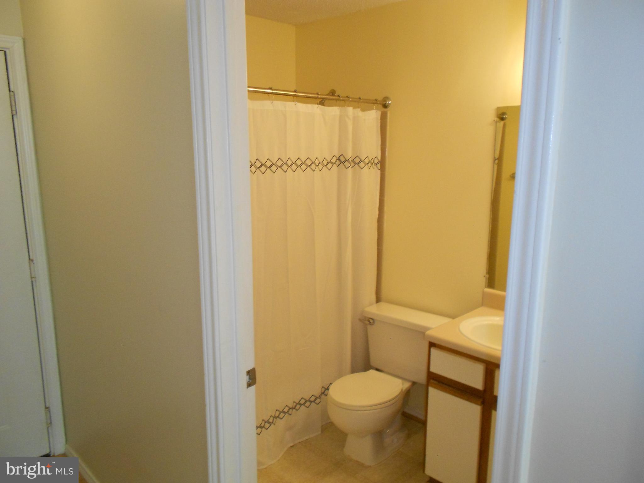 20950 Timber Ridge Terrace, Unit 203 Ashburn, VA 20147 - Photo 13 of 30 a bathroom with a granite countertop toilet and a sink