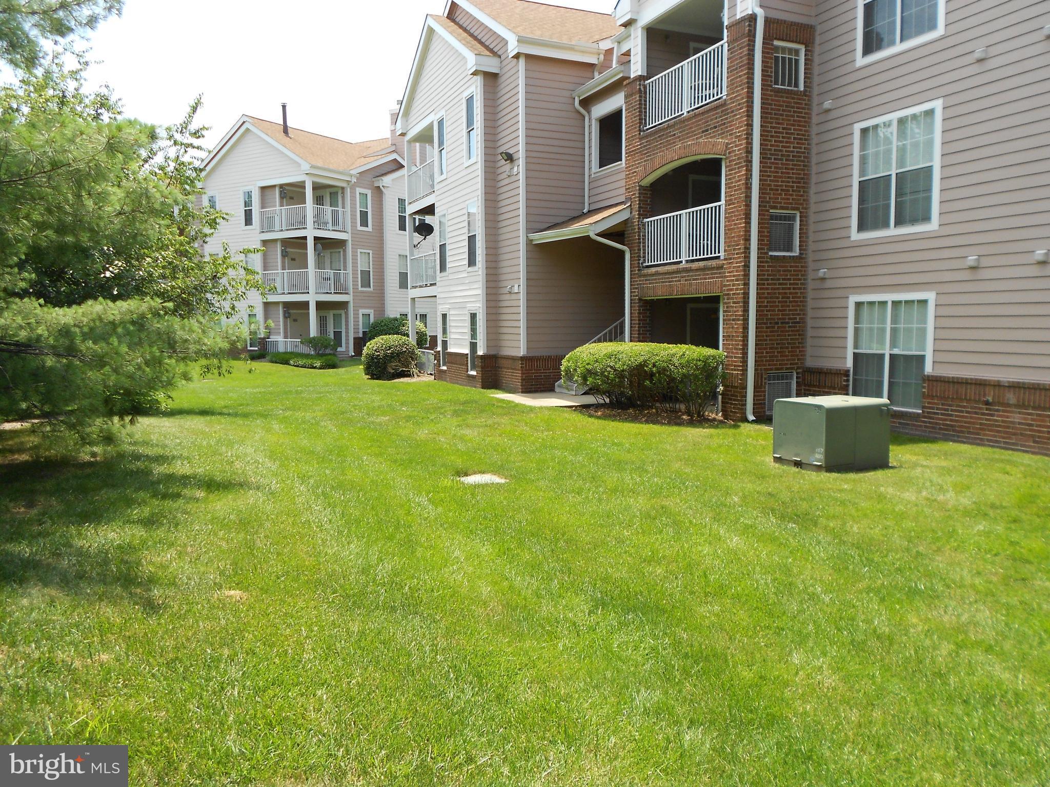20950 Timber Ridge Terrace, Unit 203 Ashburn, VA 20147 - Photo 22 of 30 a view of a house with a yard and sitting area