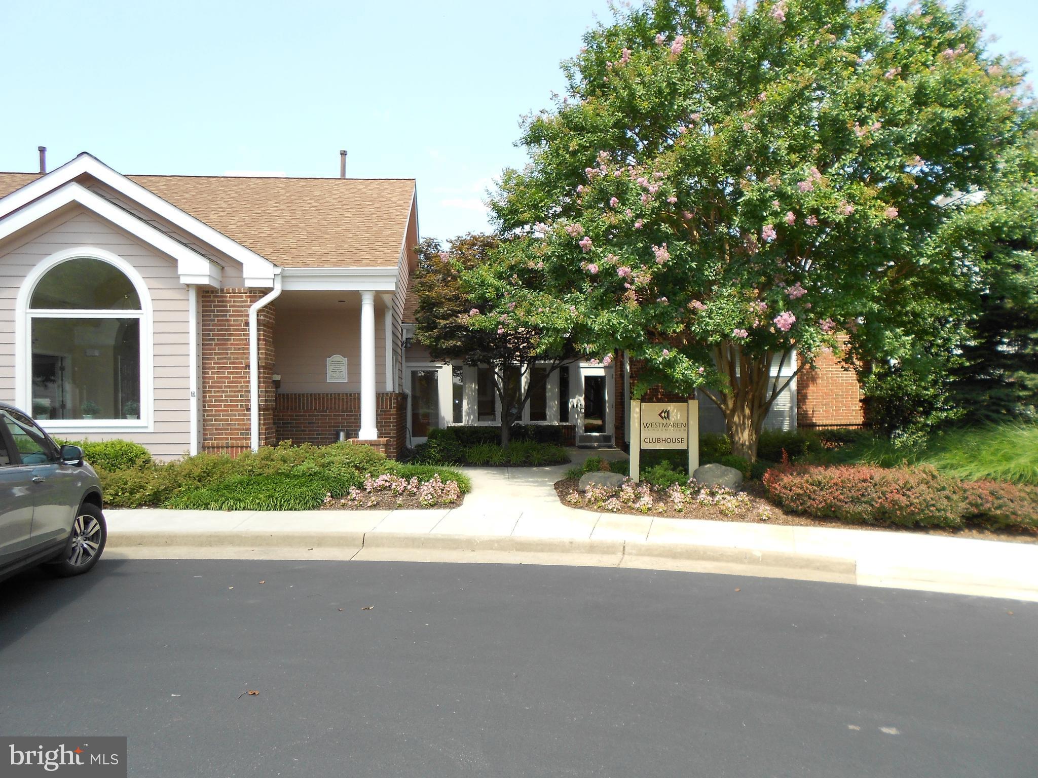 20950 Timber Ridge Terrace, Unit 203 Ashburn, VA 20147 - Photo 25 of 30 a front view of a house with a yard and garage