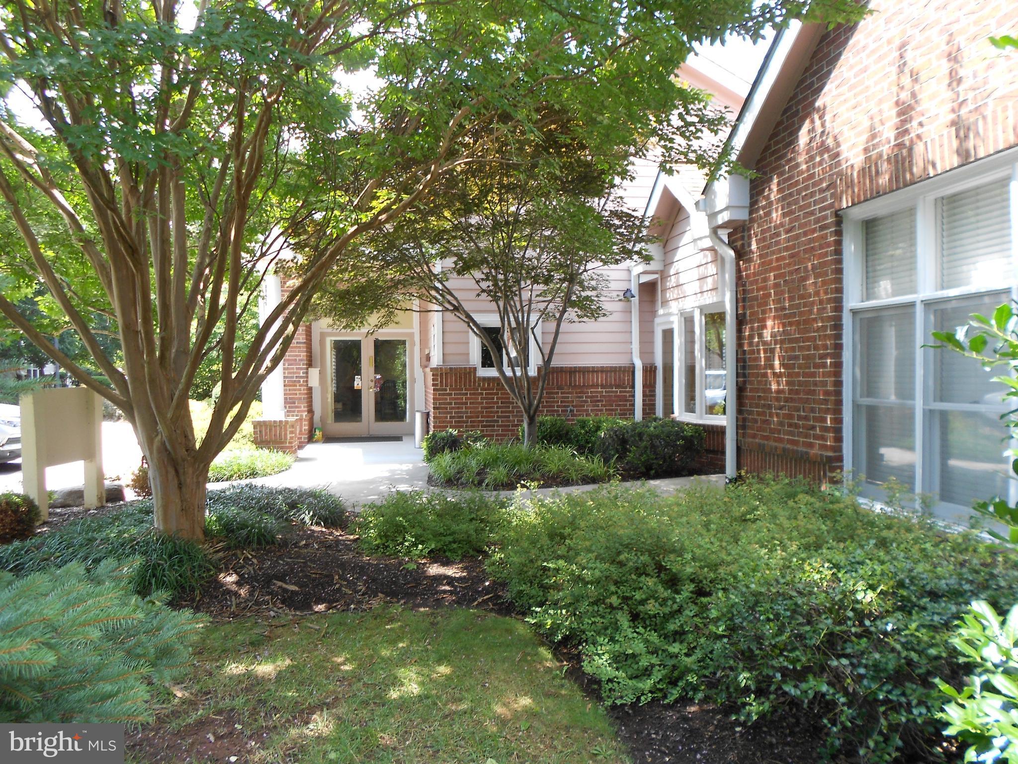 20950 Timber Ridge Terrace, Unit 203 Ashburn, VA 20147 - Photo 27 of 30 a front view of a house with garden
