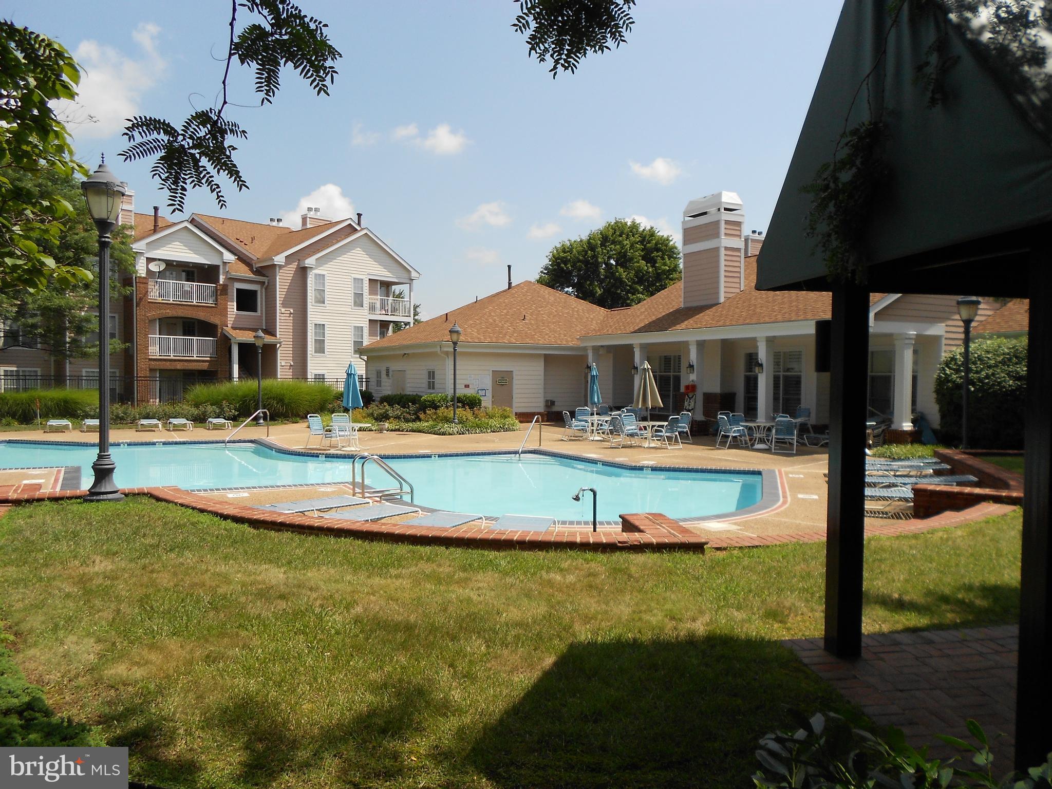 20950 Timber Ridge Terrace, Unit 203 Ashburn, VA 20147 - Photo 30 of 30 a view of a white house with a swimming pool table and chairs