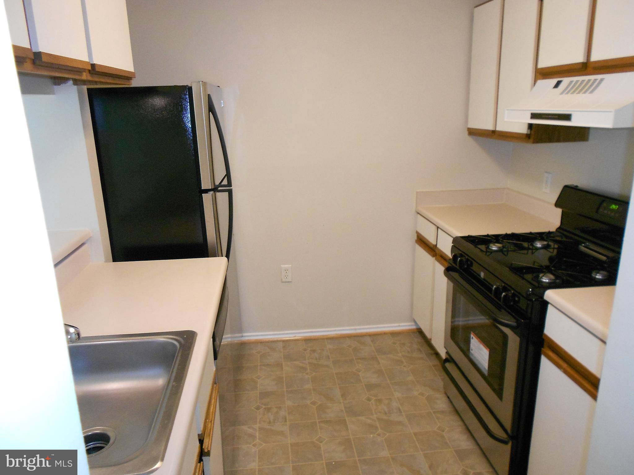 20950 Timber Ridge Terrace, Unit 203 Ashburn, VA 20147 - Photo 7 of 30 a kitchen with a refrigerator and a stove
