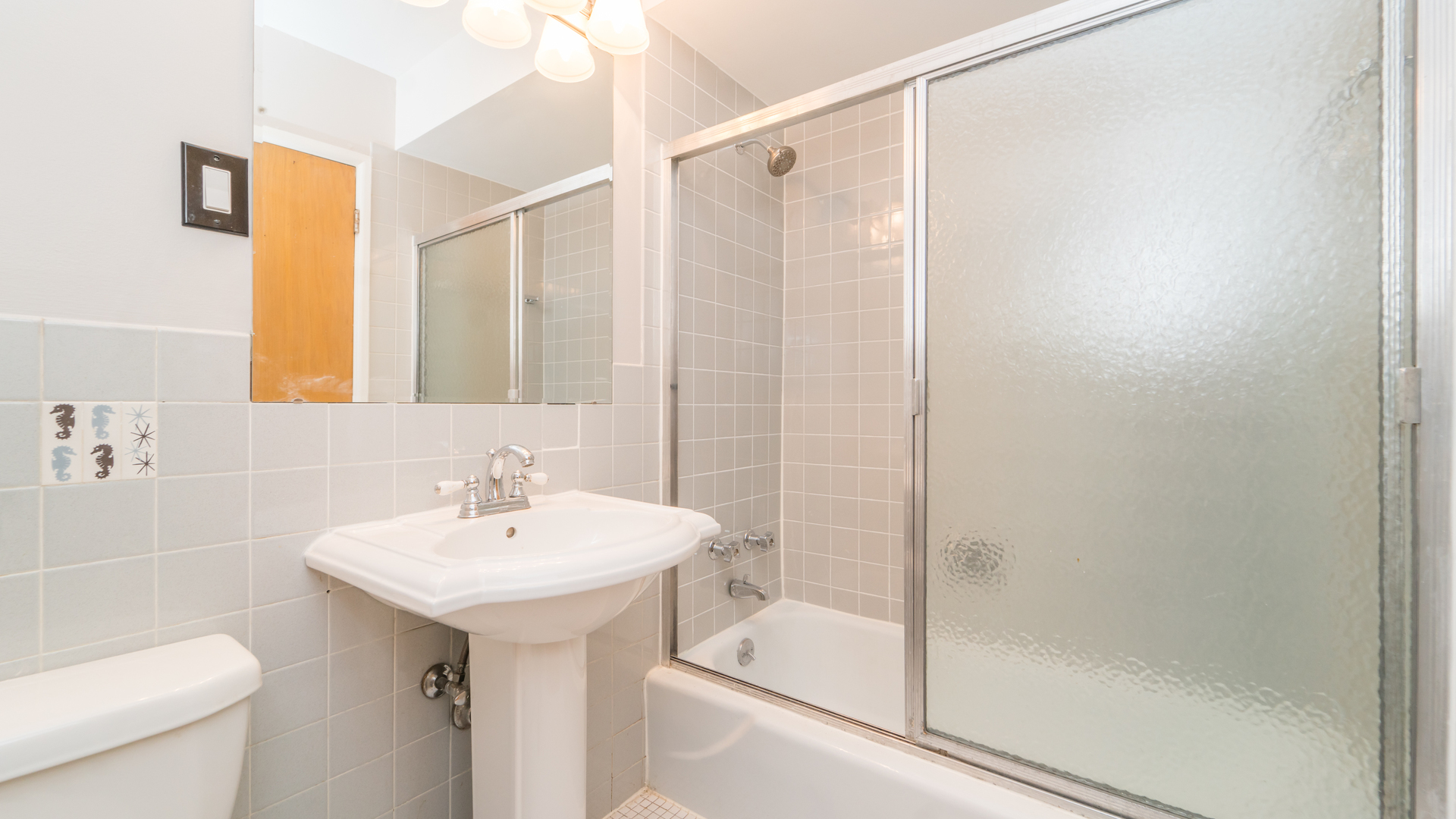 7120 North Sheridan Road, Unit 401 Chicago, IL 60626 - Photo 9 of 9 a bathroom with a sink mirror toilet and shower