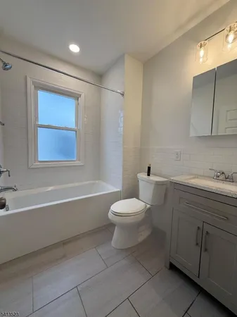 a bathroom with a toilet a sink a mirror and bathtub