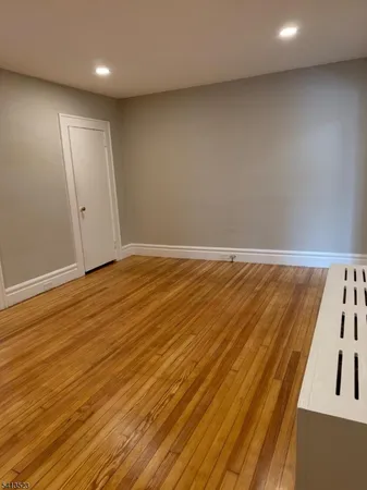 an empty room with wooden floor and entrance