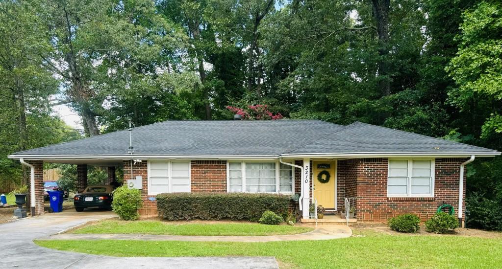 3210 North Druid Hills Road Northeast Decatur, GA 30033 - Photo 1 of 1 a front view of a house with a yard table and chairs