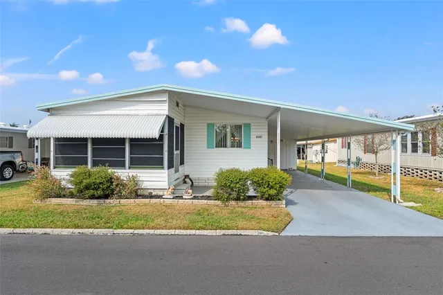 a front view of a house with a yard and potted plants