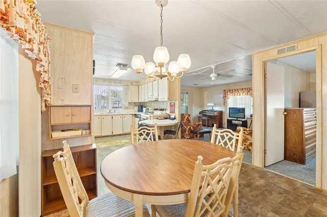 a view of a dining room with furniture and a chandelier