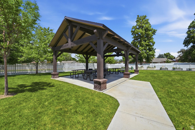 6969 South 855 East Midvale, UT 84047 - Photo 54 of 55 Spacious outdoor pavilion featuring exposed timber framing, brick column bases, a concrete patio, and surrounding green space with mature trees