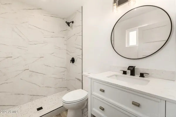 a bathroom with a sink a toilet and a mirror