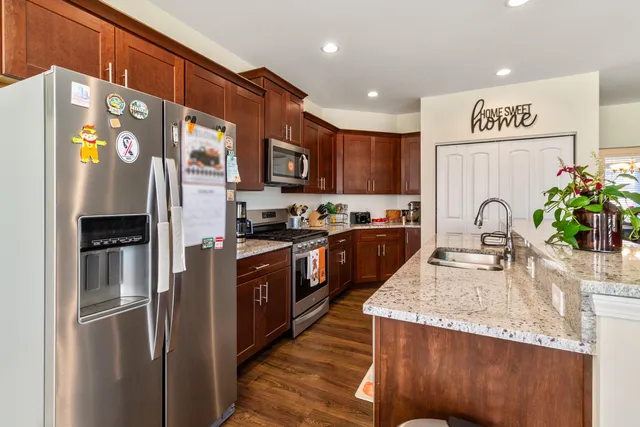 a kitchen with granite countertop a refrigerator and a sink