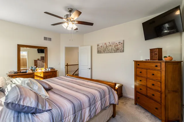 a bedroom with a bed a flat screen tv and dresser