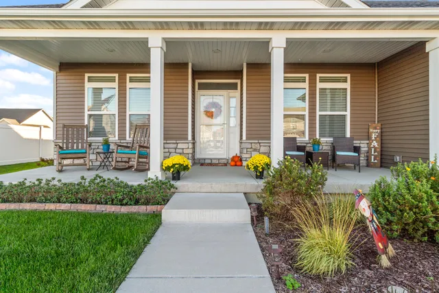 a view of a house with potted plants and a bench