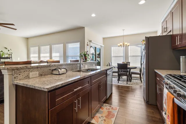 a kitchen with stainless steel appliances granite countertop a sink stove and refrigerator