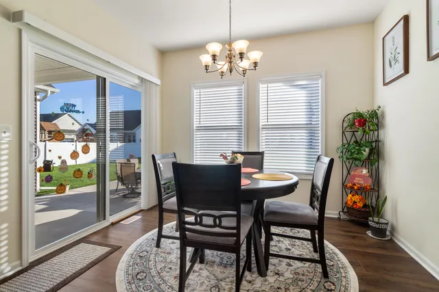 a dining room with furniture a chandelier and wooden floor