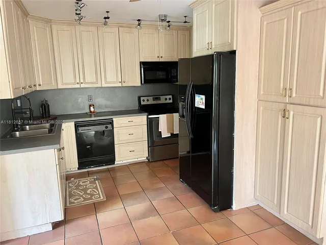 a kitchen with stainless steel appliances granite countertop a refrigerator and a stove