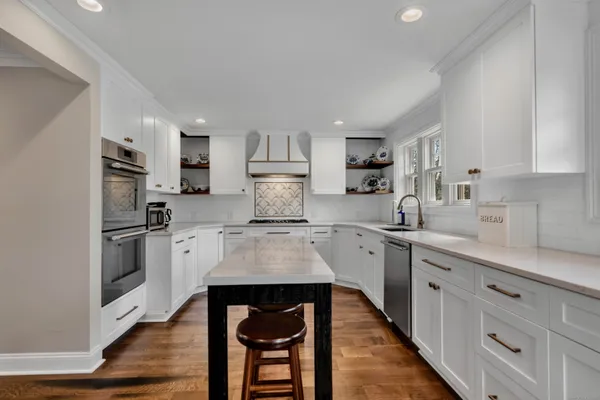 a kitchen with granite countertop white cabinets and stainless steel appliances