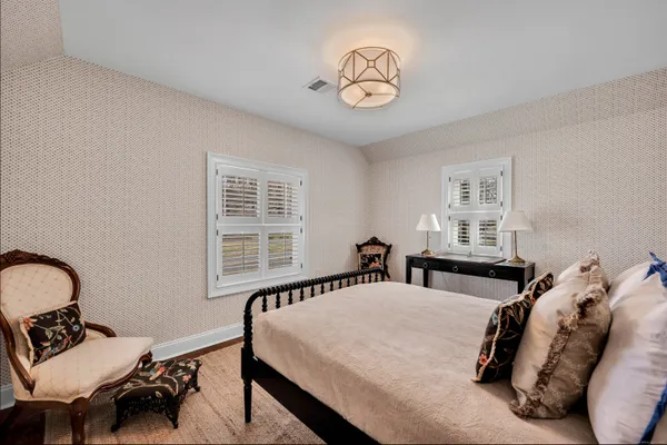 a bedroom with a bed a chandelier and a window
