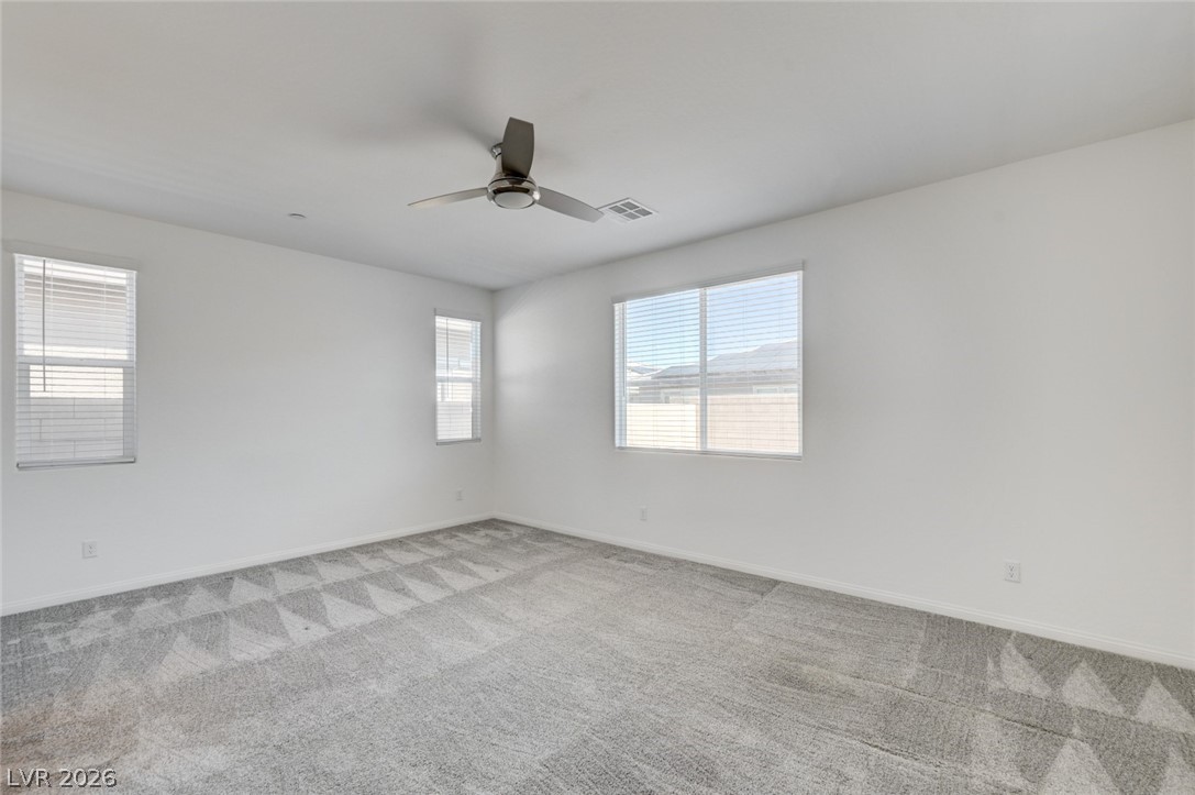 756 Cadence View Way Henderson, NV 89011 - Photo 11 of 45 Empty room with light carpet and a ceiling fan