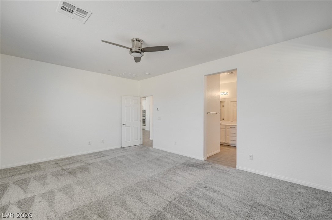 756 Cadence View Way Henderson, NV 89011 - Photo 13 of 45 Unfurnished bedroom with a ceiling fan, light colored carpet, and ensuite bathroom