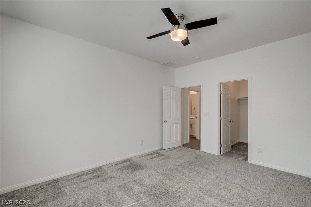 756 Cadence View Way Henderson, NV 89011 - Photo 25 of 45 Unfurnished bedroom featuring a walk in closet, light carpet, and a ceiling fan