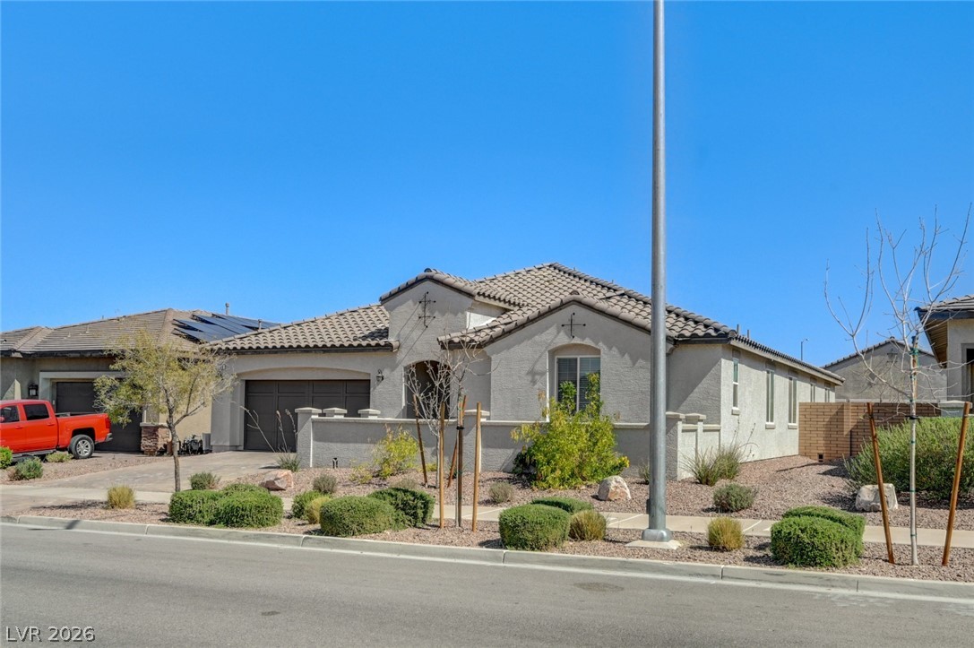 756 Cadence View Way Henderson, NV 89011 - Photo 3 of 45 View of front of home with a fenced front yard, driveway, an attached garage, and stucco siding