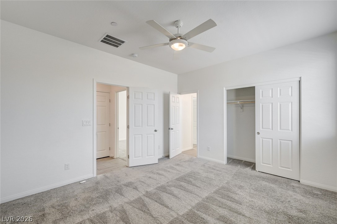 756 Cadence View Way Henderson, NV 89011 - Photo 29 of 45 Unfurnished bedroom with a ceiling fan, light carpet, and a closet