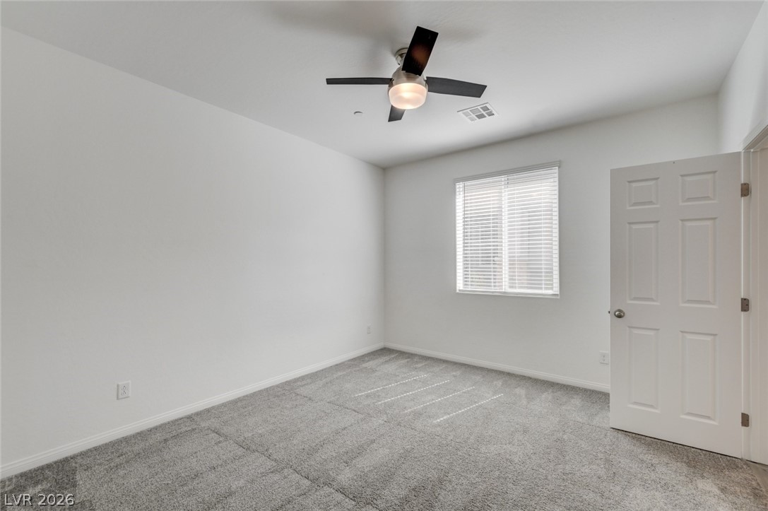 756 Cadence View Way Henderson, NV 89011 - Photo 33 of 45 Empty room with light colored carpet and ceiling fan