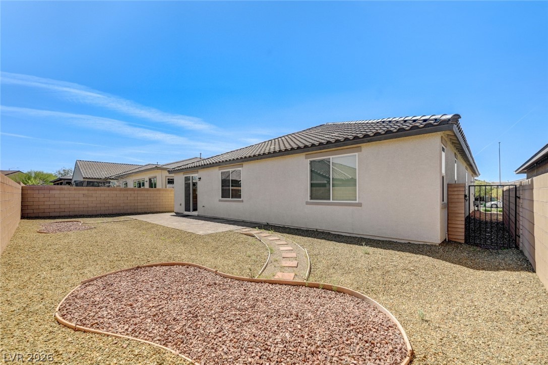 756 Cadence View Way Henderson, NV 89011 - Photo 42 of 45 Rear view of property featuring a patio, a fenced backyard, stucco siding, a tiled roof, and a gate