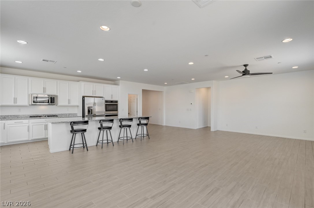 756 Cadence View Way Henderson, NV 89011 - Photo 44 of 45 Kitchen with a center island with sink, white cabinetry, a kitchen bar, open floor plan, and recessed lighting
